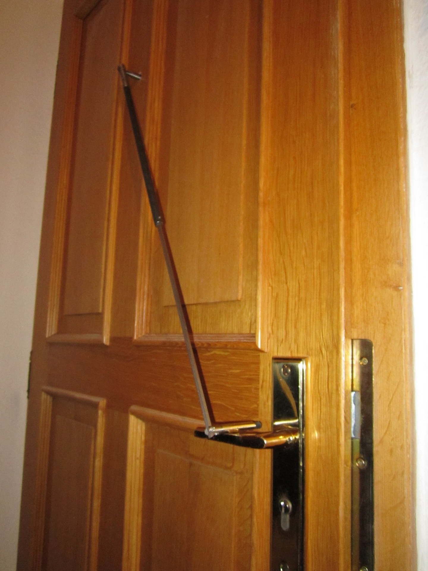 Eine Tür wird mit einem Werkzeug durch den Spion geöffnet